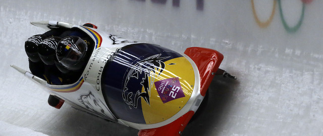 The team from Romania ROU-1, with Andreas Neagu, Florin Craciun, Paul Muntean and Danut Moldovan, take a curve during the men's four-man bobsled competition at the 2014 Winter Olympics, Saturday, Feb. 22, 2014, in Krasnaya Polyana, Russia. (AP Photo/Dita Alangkara)