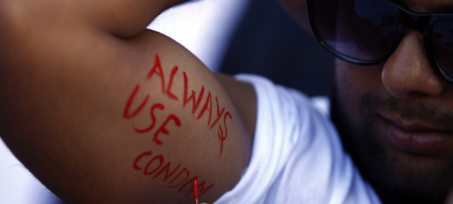 A Nepalese man paints on his arms "Always use condom" message at an event to mark World AIDS Day in Katmandu, Nepal, Sunday, Dec. 1,2013. World AIDS Day is celebrated on Dec. 1 every year to raise awareness about HIV/AIDS.(AP Photo/Niranajan Shrestha)