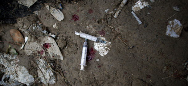Blood and two heroin syringes are pictured near the Kabul River in Kabul on April 25, 2012. Between 2005 and 2009 the number of Afghan heroin addicts tripled to 150,000, according to the United Nations, with 230,000 people now using opium. Afghanistan grows about 90 percent of the world's opium, says the UN drugs and crime office UNODC. It estimates that export earnings last year from Afghan opiates were worth 2.4 billion USD-- equivalent to 15 per cent of GDP. AFP PHOTO/ JOHANNES EISELE (Photo credit should read JOHANNES EISELE/AFP/GettyImages)