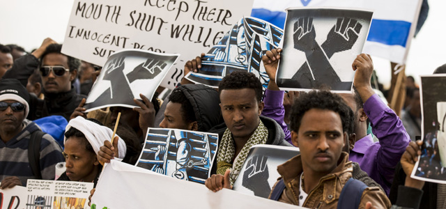 African asylum seekers, who entered Israel illegally via Egypt, stage a protest outside the Holot detention centre in Israel's southern Negev Desert, on February 17, 2014. The Israeli government has opened last year the sprawling Holot detention facility to house both new entrants and immigrants already in the country deemed to have disturbed public order. Tens of thousands of migrants, mostly Eritrean and Sudanese, have been staging mass demonstrations in the country against moves by the Israeli authorities to track them down and deport them, or throw them into detention facilities without trial. AFP PHOTO/JACK GUEZ (Photo credit should read JACK GUEZ/AFP/Getty Images)
