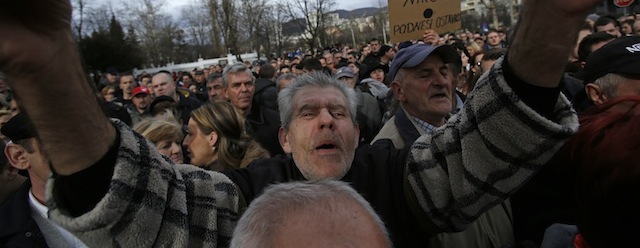 Bosnian people march as one holds up a banner that reads: “We Want Government Resignation”, during a protest in the Bosnian capital of Sarajevo, Monday Feb. 10, 2014. Thousands are protesting in Bosnia for a sixth day, demanding that politicians resign and a new government of non-partisan experts be put in to address the country's nearly 40 percent unemployment and rampant corruption. (AP Photo/Amel Emric)