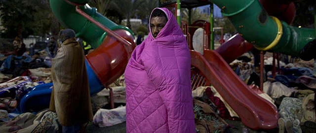 African migrants cover themselves with blankets in a park during a protest demanding asylum and work rights from the Israeli government, in Tel Aviv, Israel, early Tuesday, Feb. 4, 2014. In recent weeks, African migrants, mostly from Eritrea and Sudan, have staged a series of demonstrations demanding they be recognized as refugees, a status that would give them residency rights. Israel sees many of them as economic migrants and has tried a number of tactics to stop the migrants' influx or keep their numbers down. It has built a fence along the border with Egypt, passed a law that allows for the migrants' detention and offered financial incentives to urge them to leave. (AP Photo/Oded Balilty)
