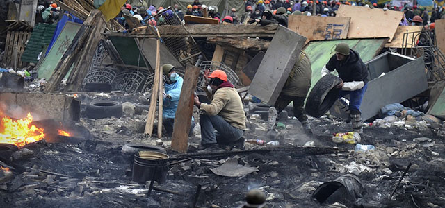 Anti-government protesters clash with riot police in central Kiev on February 20, 2014. At least 25 protesters were killed on February 20 in fresh clashes between thousands of demonstrators and heavily-armed riot police in the heart of Kiev, AFP correspondents at the scene said. The bodies of eight demonstrators were lying outside Kiev's main post office on Independence Square, an AFP reporter said. The bodies of 17 other demonstrators with apparent gunshot wounds were also seen in the vicinity of two hotels on opposite sides of the protest encampment. AFP PHOTO / LOUISA GOULIAMAKI (Photo credit should read LOUISA GOULIAMAKI/AFP/Getty Images)