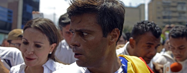 Leopoldo Lopez (C), an ardent opponent of Venezuela's socialist government facing an arrest warrant after President Nicolas Maduro ordered his arrest on charges of homicide and inciting violence, prepares to turn himself in to the national guard, during a demonstration in Caracas, on February 18, 2014. Fugitive Venezuelan opposition leader Lopez, blamed by Maduro for violent clashes that left three people dead last week, appeared at an anti-government rally in eastern Caracas and quickly surrendered to the National Guard after delivering a brief speech. AFP PHOTO / LEO RAMIREZ (Photo credit should read LEO RAMIREZ/AFP/Getty Images)