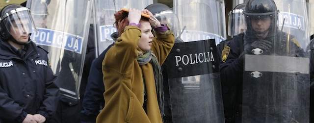 Bosnian police forces secure the entrance as protesters stone the local government building in Bosnian town of Tuzla, 140 kms north of Sarajevo, on Thursday, Feb. 6. 2014. Violent protests by some thousands of unpaid workers in a northern Bosnian city spread to other parts of the country Thursday and have morphed into widespread discontent about unemployment and alleged rampant corruption, in an election year. Police used tear gas to temporarily disperse the protesters in Tuzla who threw stones at a local government building, then the protesters returned after the tear gas volley, surrounded the empty government building and set tyres and trash on fire. (AP Photo/Amel Emric)