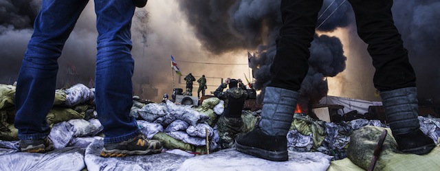 Anti-government demonstrators stand on barricades during clashes with riot police in Kiev on February 18, 2014. Opposition leader Vitali Klitschko on February 18 urged women and children to leave the opposition's main protest camp on Kiev's Independence Square, known as Maidan, as riot police massed nearby. "We ask women and children to quit Maidan as we cannot rule out the possibility that they will storm (the camp)," the former heavyweight boxing champion told protestors on the square. AFP PHOTO / SANDRO MADDALENA (Photo credit should read SANDRO MADDALENA/AFP/Getty Images)