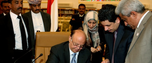 In this photo provided by Yemen's Defense Ministry, Yemeni President Abed Rabbo Mansour Hadi signs the final approval on transforming Yemen into a federal state of six regions in Sanaa Yemen, Monday, Feb. 10, 2014. A key Yemeni panel tasked with devising a new system to address the local grievances that have fed the impoverished Arabian Peninsula nation's instability agreed Monday to transform the country into a state of six regions. (AP Photo/Yemen's Defense Ministry)