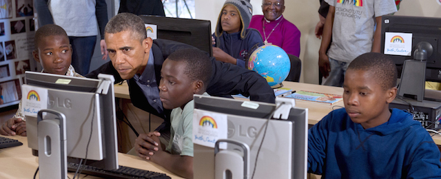 US President Barack Obama (2L) sits down at a computer as he tours a classroom at the Desmond Tutu HIV Foundation Youth Centre in Cape Town, South Africa, on June 30, 2013. Nobel peace laureate Archbishop Desmond Tutu met visiting President Barack Obama at his foundation's HIV Centre in the city, where he said it was a "special joy" to welcome the US leader to "the continent of his forebears". AFP PHOTO / Saul LOEB (Photo credit should read SAUL LOEB/AFP/Getty Images)