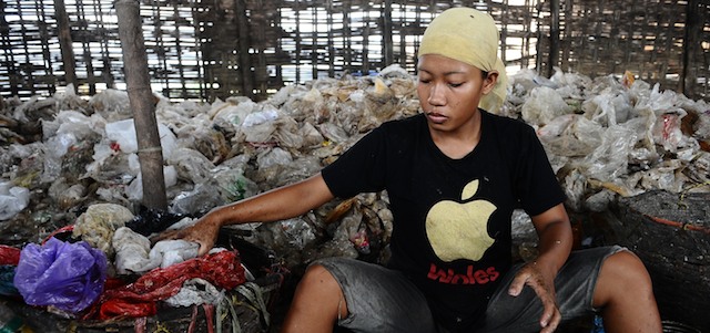 SURABAYA, INDONESIA - MARCH 07: A woman sifts through garbage from a landfill at Benowo on March 7, 2014 in Surabaya, Indonesia. These women work at the landfill site everyday earning an average of USD $2. Millions of Indonesian women are currently living below the poverty line. According to the Indonesia Central Bureau of Statistics in March 2013, the number of poor in Indonesia reached 28.07 million people, and 70 % of them are women. Tomorrow, around the world, International Women's day is observed, celebrating the economic, political and social achievements of women past, present and future. (Photo by Robertus Pudyanto/Getty Images)