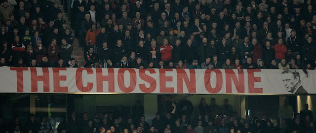 Manchester United fans watch the action beside a banner calling manager David Moyes 'The Chosen One' during during the English Premier League football match between Manchester United and Manchester City at Old Trafford in Manchester on March 25, 2014. AFP PHOTO/PAUL ELLIS - RESTRICTED TO EDITORIAL USE. No use with unauthorized audio, video, data, fixture lists, club/league logos or live services. Online in-match use limited to 45 images, no video emulation. No use in betting, games or single club/league/player publications. (Photo credit should read PAUL ELLIS/AFP/Getty Images)