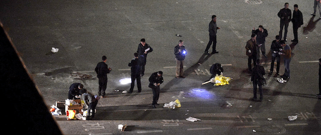 Police officers investigate the crime scene outside a railway station after an attack by knife wielding men leaving some 27 people dead in Kunming, in southwestern China's Yunnan province, Saturday March 1, 2014. China's official Xinhua News Agency says authorities consider the attack by a group of knife-wielding assailants at a train station in southwestern China in which at least 27 people died to be an act of terrorism. (AP Photo) CHINA OUT