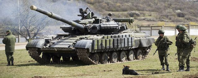 Russian soldiers stand near a tank at a former Ukrainian military base in Perevalne, outside Simferopol, Crimea, March 27, 2014. Russia last week completed the annexation of Crimea following a referendum in which an overwhelming number of residents voted to break off from Ukraine and join Russia. The vote, rejected by Ukraine and the West, was hastily called after Russian forces had overtaken the peninsula. (AP Photo/Pavel Golovkin)