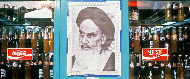 Una foto dell'ayatollah Ruhollah Khomeini sulla vetrina di un negozio, in cui sono visibili bottiglie di Coca Cola, gennaio 1979. 
(AFP/Getty Images)