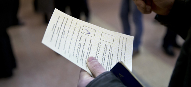 A man holds a ballot after casting a vote in favor of separation from Ukraine in the Crimean referendum in Simferopol, Ukraine, Sunday, March 16, 2014. Residents of Ukraine's Crimea region are voting in a contentious referendum on whether to split off and seek annexation by Russia. (AP Photo/Vadim Ghirda)