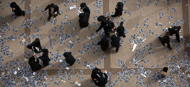 Ultra Orthodox Jews walk past flying leaflets as they gather along with hundreds of thousands on March 2, 2014, in Jerusalem to demonstrate against any plans to make them undergo military service. The protests were sparked by cuts in government funding to Jewish theological seminaries, or yeshivas, and a planned crackdown on young ultra-Orthodox men seeking to avoid Israel's compulsory military draft. AFP PHOTO/MENAHEM KAHANA (Photo credit should read MENAHEM KAHANA/AFP/Getty Images)