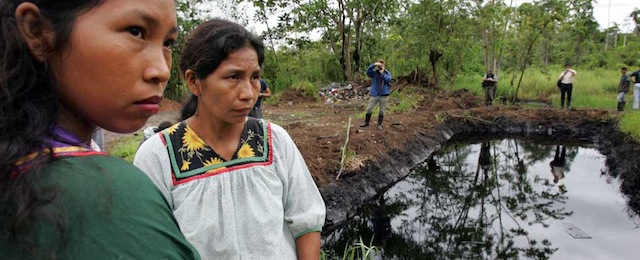 ** ADVANCE FOR SUNDAY, DEC. 21 ** Cofan indigenous women stand near a pool of oil in Ecuador's Amazonian region, Oct. 20, 2005. Ecuador's President Rafael Correa has sided squarely with the 30,000 plaintiffs, Indians and colonists, in a class-action suit, dubbed an Amazon Chernobyl by environmentalists, over the slow poisoning of a Rhode Island-sized expanse of rainforest with millions of gallons of oil and billions more of toxic wastewater. (AP Photo/Dolores Ochoa) ** NO ONLN ** NO IONLN **