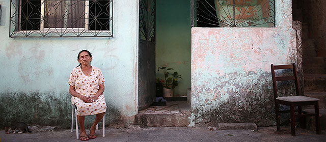 RIO DE JANEIRO, BRAZIL - MARCH 18: A resident sits in the unpacified Complexo da Mare slum complex, one of the largest 'favela' complexes in Rio, on March 18, 2014 in Rio de Janeiro, Brazil. The group of 16 communities house around 130,000 residents while plagued by violence and dominated by drug gangs. The settlement of the area began in the 1940's. with wooden structures built over the edge of Guanabara Bay. Mare is located close to Rio's international airport and has been mentioned as a likely pacification target for the police. Rio's Police Pacification Unit (UPP) now controls 38 of the city favelas amid the city's efforts to improve security ahead of the 2014 FIFA World Cup and 2016 Olympic Games. (Photo by Mario Tama/Getty Images)