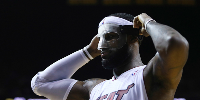 Miami Heat's LeBron James adjusts his protective mask during the first half of an NBA basketball game in Miami, Monday, March 3, 2014 against the Charlotte Bobcats. (AP Photo/J Pat Carter)