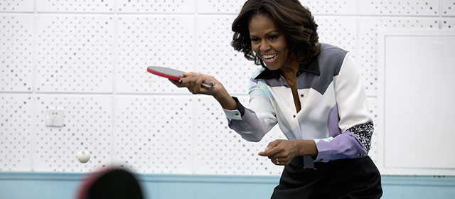 Michelle Obama gioca a ping pong durante una visita in una scuola a Pechino che prepara gli studenti a studiare all'estero, 21 marzo 2014. 
(ANDY WONG/AFP/Getty Images)