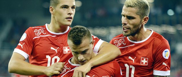 Switzerland's Xherdan Shaqiri, center, flanked by Valon Behrami, right, and Granit Xhaka, left, celebrate after the first goal for Switzerland during a World Cup 2014 group E qualification soccer match between Switzerland and Albania at the Swisspor Arena in Lucerne, Switzerland, Tuesday, Sept. 11, 2012. (AP Photo/Keystone/Walter Bieri)