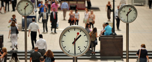 City workers walk past clocks showing 1230 GMT (1330 BST) in Canary Wharf, east London, on August 5, 2011, shortly before US employment figures were announced. Global stocks plunged on Friday on the increasing prospect of a sharp economic downturn, with attention focused on US jobs data, widely expected to deepen the gloom of flagging growth and eurozone debt. AFP PHOTO/Ben Stansall (Photo credit should read BEN STANSALL/AFP/Getty Images)