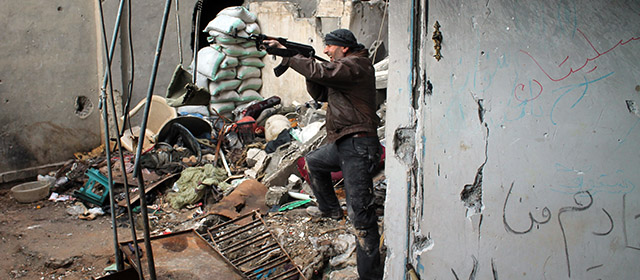 A rebel fighter fires at pro-regime fighters, during clashes in the eastern Syrian town of Deir Ezzor on March 13, 2014. Syria's parliament approved a new election law, on March 14, which for the first time in decades allows multiple candidates to run for president, just months before the war-torn nation heads to the polls. AFP PHOTO/AHMAD ABOUD (Photo credit should read AHMAD ABOUD/AFP/Getty Images)