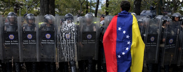 A Venezuelan student stands in front of riot police during a protest against the government of President Nicolas Maduro, in Caracas on March 12, 2014. A young man was shot dead in a confused event during protests in the city of Valencia, in northern Venezuela. About 3,000 Venezuelan students marched Wednesday to mark a month since the first deaths in anti-government protests that have now claimed at least 22 lives. AFP PHOTO/LEO RAMIREZ (Photo credit should read LEO RAMIREZ/AFP/Getty Images)