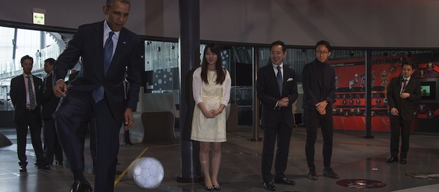 US President Barack Obama (L) stops a football that was kicked to him by humanoid robot ASIMO, an acronym for Advanced Step in Innovative MObility, as he tours the Miraikan Science Expo in Tokyo on April 24, 2014. Obama earlier vowed to defend Japan if China attacks over a tense territorial dispute, but also urged Beijing to help stop North Korea from forging ahead with its "dangerous" nuclear programme. AFP PHOTO / Jim WATSON (Photo credit should read JIM WATSON/AFP/Getty Images)