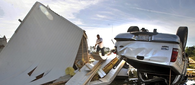 A man tries to salvage belongings from a overturned mobile home in Greenville, N.C. on Saturday, April 26, 2014 after a tornado touched down along Black Jack Simpson Road on Friday. Officials said multiple tornadoes damaged more than 200 homes the previous day and sent more than a dozen people to the emergency room. (AP Photo/The Daily Reflector, Aileen Devlin)