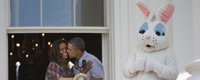 The Easter Bunny watches as President Barack Obama kisses first lady Michelle Obama, Monday, April 21, 2014, on the Truman Balcony of the White House in Washington during the White House Easter Egg Roll on the South Lawn. Thousands of children are gathered at the White House for the annual Easter Egg Roll. This year's event features live music, cooking stations, storytelling, and of course, some Easter egg rolling. (AP Photo/Carolyn Kaster)