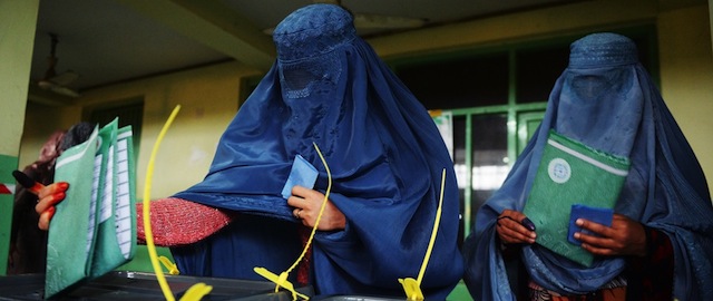 Afghan women cast their ballots at a local polling station in Kabul on April 5, 2014. Afghan voters went to the polls to choose a successor to President Hamid Karzai, braving Taliban threats in a landmark election held as US-led forces wind down their long intervention in the country. Afghanistan's third presidential election brings an end to 13 years of rule by Karzai, who has held power since the Taliban were ousted in a US-led invasion in 2001, and will be the first democratic handover of power in the country's turbulent history. AFP PHOTO/SHAH MARAI (Photo credit should read SHAH MARAI/AFP/Getty Images)