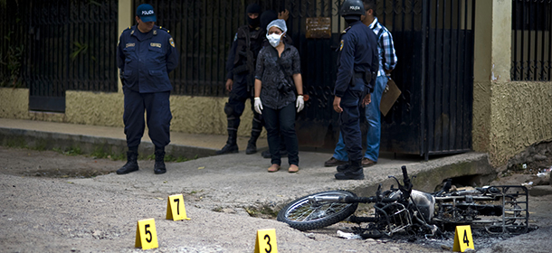 Forensic personnel work on the scene where an alleged gang member was killed by the police after a shooting at El Pedregal neighborhood in Tegucigalpa, on November 21, 2013. Honduras, considered the world's most violent country with a murder rate of 85,5 per 10,000 of population, will hold general elections next November 24th. AFP PHOTO/ Jose CABEZAS (Photo credit should read Jose CABEZAS/AFP/Getty Images)