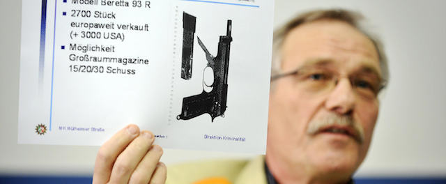 The head of the police inspection division, Heinz Sprenger, holds up a photo showing the weapon probably uses during the Italian mafia massacre in Duisburg on August 15, 2007 outside a pizza restaurant in Duisburg, during a press conference in Duisburg, western Germany, on March 13, 2009. Giovanni Strangio, suspected of leading the shootout, was arrested in Amsterdam along with his brother-in-law Francesco Romeo, both thought to belong to the southern 'Ndrangheta mafia, Renato Cortese, head of the Calabria police intervention force, told AFP March 13. Strangio had been on the run since 1997. AFP PHOTO DDP/ VOLKER HARTMANN GERMANY OUT (Photo credit should read VOLKER HARTMANN/AFP/Getty Images)