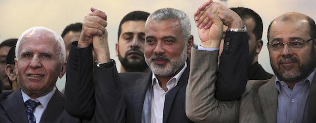 Senior Fatah official Azzam al-Ahmad, left, Gaza's Hamas Prime Minister Ismail Haniyeh, center, and senior Hamas leader Moussa Abu Marzouk, who is based in Egypt, after the announcement of an agreement between the two rival Palestinian groups, Hamas and Fatah, at Haniyeh's residence in Shati Refugee Camp, Gaza Strip, Wednesday, April 23, 2014. Rivals Hamas and Fatah made a new attempt Wednesday to overcome the Palestinians' political split, saying they would seek to form an interim unity government within five weeks, followed by general elections by December at the earliest. (AP Photo/Adel Hana)