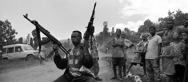 11/18/96 - Location: Zaire - Caption: A Mai-Mai rebel soldier shows off his guns at a checkpoint near Mugunga camp. - Photo By Carol Guzy TWP