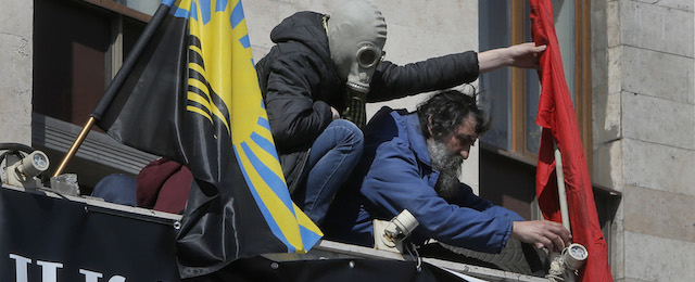 Attivisti filo-russi issano le loro bandiere su un balcone della sede dell'amministrazione regionale a Donetsk, 8 aprile 2014.
(AP Photo/Efrem Lukatsky)