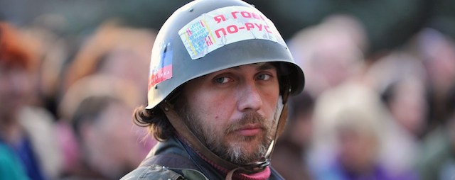 Un attivista filorusso indosa un elmetto con scritto: "Io parlo russo" durante una manifestazione di fronte a un edificio occupato a Sloviansk, 18 aprile 2014
(GENYA SAVILOV/AFP/Getty Images)