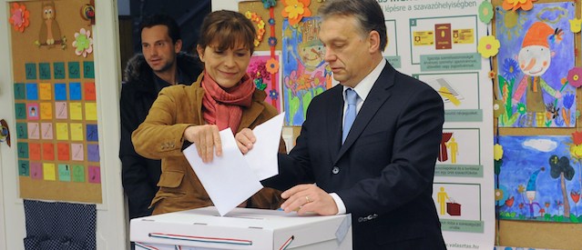 Hungarian Prime Minister Viktor Orban (R) and his wife Aniko Levai (L) put their ballots into the box in a polling station of a local school at12th district of Budapest on April 6, 2014. Hungarians vote today in parliamentary elections that look set to give strongman Orban, another term after four turbulent years that have seen him labelled both saviour and autocrat. AFP PHOTO / ATTILA KISBENEDEK (Photo credit should read ATTILA KISBENEDEK/AFP/Getty Images)