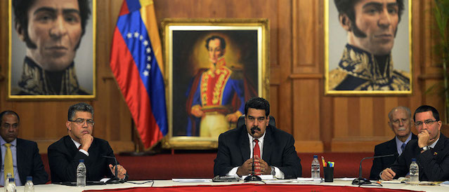 Venezuelan President Nicolas Maduro (C), accompanied by Vice-President Jorge Arreaza (R) and Foreign Minister Elias Jaua, holds a meeting with Venezuelan opposition leaders and Latin American Foreign Affairs Ministers at the Miraflores presidential palace in Caracas on April 10, 2014. Maduro sat down for talks with rival Henrique Capriles on Thursday in a first meeting with senior opposition figures to try to end two months of protests. The televised meeting, which involved about 20 representatives from both sides, was also witnessed by the foreign ministers of Brazil, Colombia and Ecuador, and a Vatican representative. AFP PHOTO/JUAN BARRETO (Photo credit should read JUAN BARRETO/AFP/Getty Images)