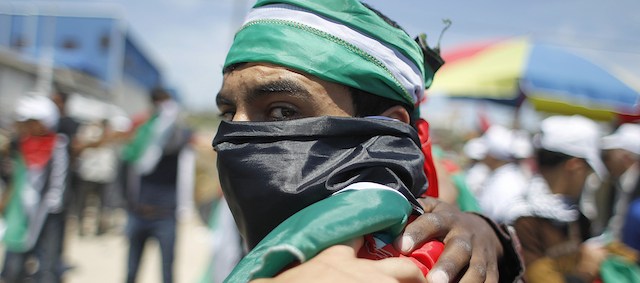 A Palestinian draped in the national flag gathers in Gaza City on May 15, 2014, to mark Nakba Day. Palestinians are marking "Nakba day" which means in Arabic "catastrophe" in reference to the birth of the state of Israel 66-years-ago in British-mandate Palestine, which led to the displacement of hundreds of thousands of Palestinians who either fled or were driven out of their homes during the 1948 war over Israel's creation. AFP PHOTO/ SAID KHATIB (Photo credit should read SAID KHATIB/AFP/Getty Images)