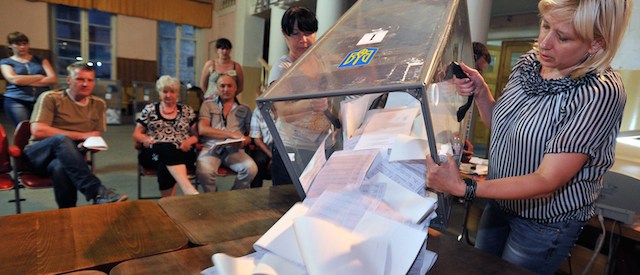 Members of the election commission empty a ballot box at a polling station in the eastern Ukrainian city of Izyum, bordering the Donetsk region during the presidential election on May 25, 2014. Billionaire Petro Poroshenko, set to become Ukraine's new president, said today that voters had made the choice of "European integration". Chocolate baron Poroshenko claimed victory today in Ukraine's presidential election, vowing to bring peace after months of turmoil and a pro-Russian insurgency that thwarted voting across much of the separatist east. The 48-year-old self-made billionaire, who exit polls said had won almost 56 percent of the vote, swiftly declared that he would work to bring peace to Ukraine. AFP PHOTO/ GENYA SAVILOV
