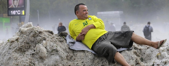 A man wearing a Brazil soccer jersey and shorts lies on a pile of hail in the Aclimacao neighborhood of Sao Paulo, Brazil, early Monday, May 19, 2014. Neighborhoods on the south side of Sao Paulo woke up to their streets covered after a hailstorm which the Center for Emergency Management says broke the dry spell that brought the city's water levels to a historic low. (AP Photo/Nelson Antoine)