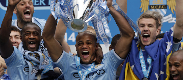 Vincent Kompany solleva la coppa consegnata al Manchester City per la vittoria della Premier League. (AP Photo/Jon Super)