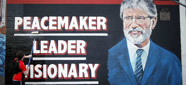 A man adds the finishing touch to a newly painted mural of Gerry Adams on the Falls Road, West Belfast, Northern Ireland, Northern Ireland, Friday, May, 2 2014. Police continue to question the Sinn Fein leader Gerry Adams at Antrim police station about the 1972 murder of Jean McConville. (AP Photo/Peter Morrison)