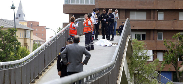 Police officers and rescue workers stand next to the covered body of Leon provincial council chief Isabel Carrasco in Leon on May 12, 2014. An assailant shot dead a Spanish ruling party politician in public in the northern city of Leon in an apparent "act of vengeance" today, officials said, and a woman was detained over the killing. Half a dozen police covered the body of Leon provincial council chief Isabel Carrasco with a white sheet at the scene on a pedestrian bridge over the Bernesga River in the university city. AFP PHOTO / ICAL / CARLOS CAMPILLO (Photo credit should read CARLOS CAMPILLO/AFP/Getty Images)