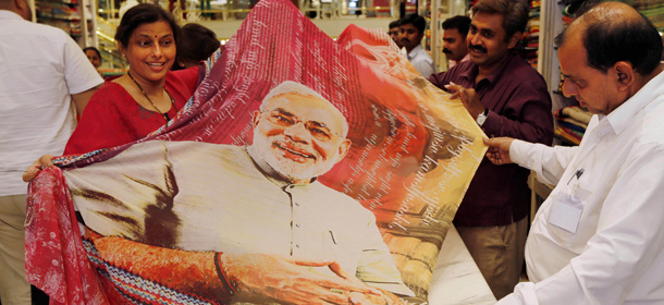 A woman customer, left, holds a sari printed with a portrait of Bharatiya Janata Party's prime ministerial candidate Narendra Modi at a garments shop in Mumbai, India, Wednesday, May 14, 2014. Official election results are expected on Friday, but exit polls by at least six major Indian TV stations show the Hindu nationalist Bharatiya Janata Party likely to win enough seats to form a coalition government. (AP Photo/Rajanish Kakade)