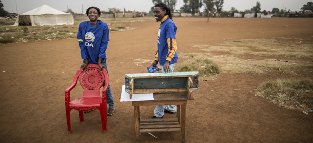 Election observers for the South Africa's main oppostion party Democratic Alliance (DA) stand in an empty plot of land outside a polling station in the impoverished Bekkersdal township on May 6, 2014. South Africa goes to polls on May 7, 2014 in the fifth democratic elections after the fall of apartheid in 1994. AFP PHOTO / MARCO LONGARI (Photo credit should read MARCO LONGARI/AFP/Getty Images)