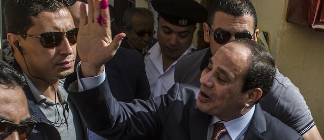 Egypt's ex-army chief and leading presidential candidate Abdel Fattah al-Sisi (R) salutes the crowd after casting his vote at a polling station in the north Cairo district of Heliopolis on May 26, 2014. Egyptians are voting for a new president, with the ex-army chief who overthrew the country's first democratically elected leader and crushed his Islamist movement expected to win in a landslide. AFP PHOTO / KHALED DESOUKI (Photo credit should read KHALED DESOUKI/AFP/Getty Images)