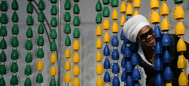 In this file photo from April 22, 2013, released by Agencia Brasil, Brazalian artist Carlinhos Brown poses with caxirolas, maraca-like instruments he created, at the Planalto Palace, in Brasilia, Brazil. The caxirola has been recognized by the Brazilian government and FIFA as the official fan instrument of the 2014 World Cup. The official noisemakers for next year's World Cup soccer tournament in Brazil will be significantly quieter than the vuvuzela horns that caused so many headaches in 2010. (AP Photo/Fabio Pozzebom-Agencia Brasil)