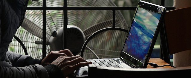 A man uses a laptop at a coffee shop in downtown Hanoi on November 28, 2013. Vietnam has intensified a crackdown on online dissent with a new decree that threatens fines of several thousand dollars for anybody criticising the government on Facebook. AFP PHOTO/HOANG DINH NAM (Photo credit should read HOANG DINH NAM/AFP/Getty Images)